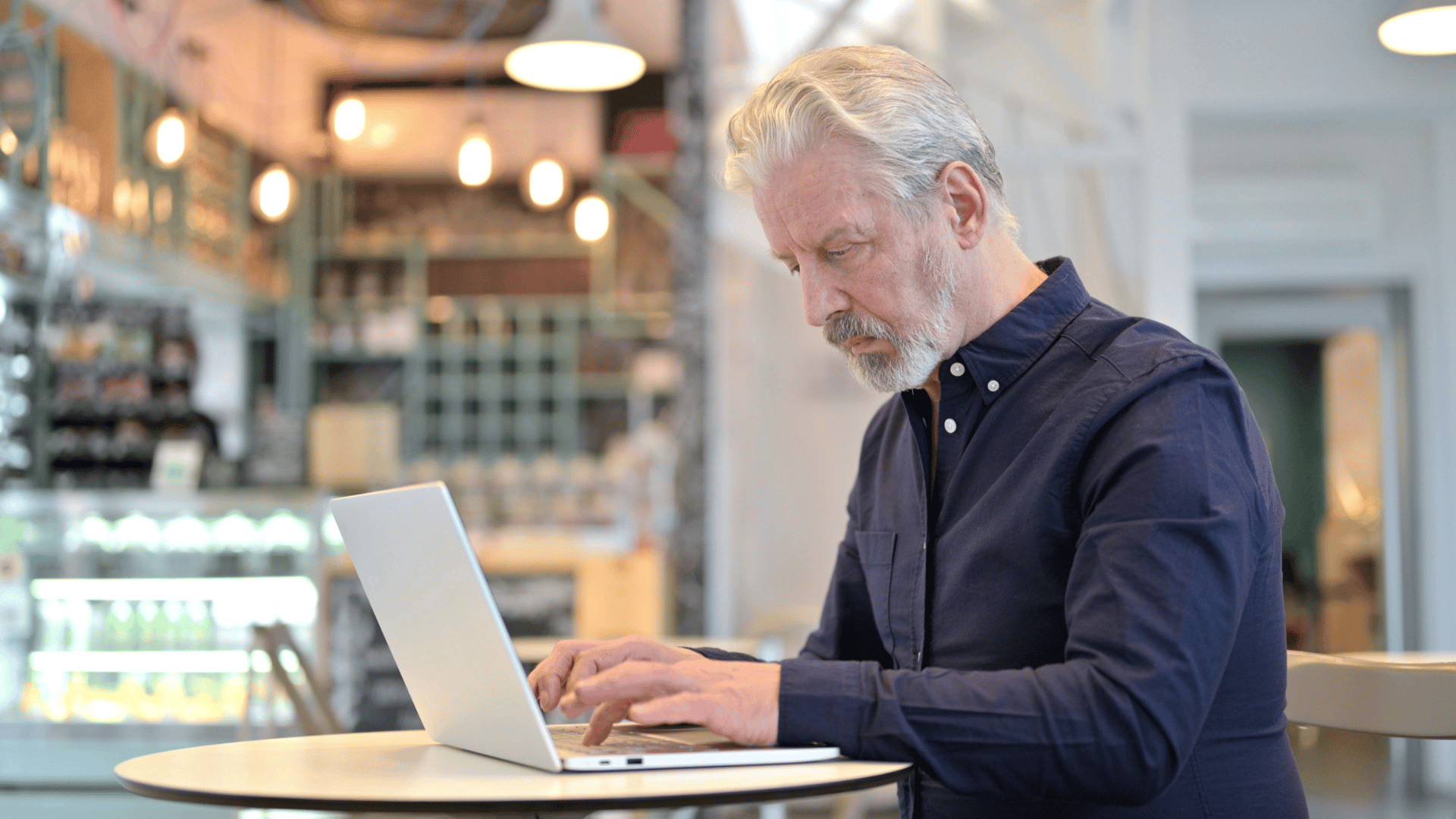 an older man working on a computer and having trouble typing